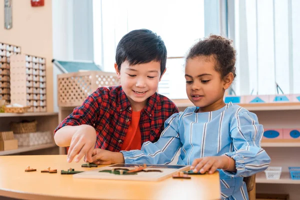 Kinder spielen mit Brettspiel aus Holz am Tisch im Montessori-Kurs — Stockfoto