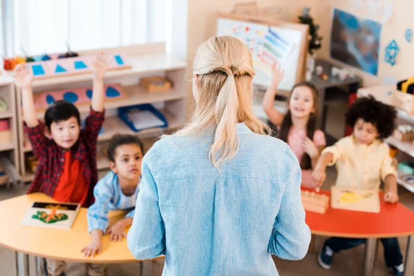 Selective focus of teacher conducting lesson with kids in montessori school — Stock Photo