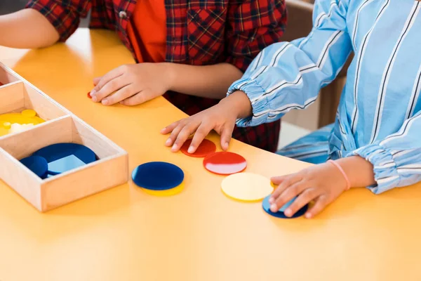 Vista cortada de crianças jogo colorido dobrável na mesa na escola montessori — Fotografia de Stock