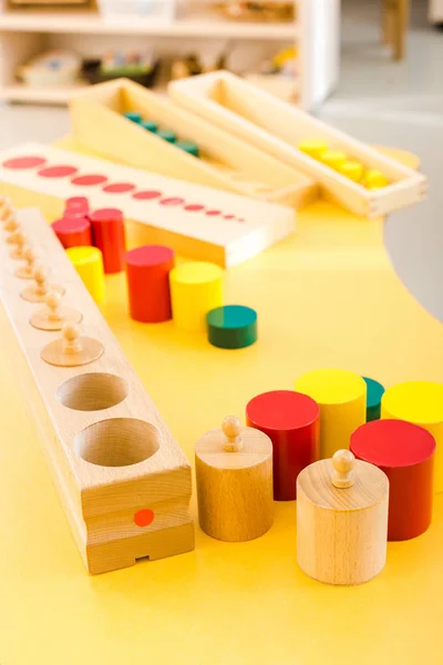 Selektiver Schwerpunkt der Holzspiele auf dem gelben Schreibtisch in der Schule — Stockfoto