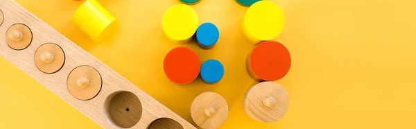 Vista dall'alto di giochi educativi in legno su sfondo giallo, colpo panoramico — Foto stock