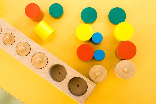 Vista superior de los juegos educativos de colores en el escritorio amarillo en clase - foto de stock