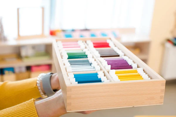 Cropped view of teacher holding colorful educational game in class — Stock Photo
