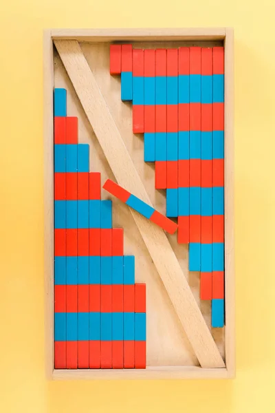 Top view of educational game with red and blue blocks on yellow background — Stock Photo