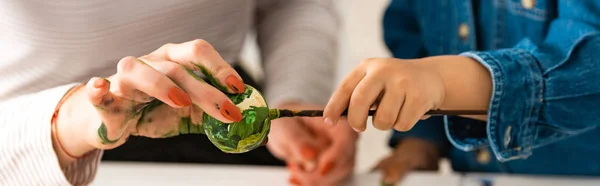 Cropped view of mother and son painting Easter egg together — Stock Photo