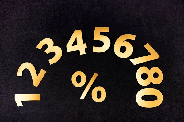 Top view of golden numbers and percent sign on black background — Stock Photo