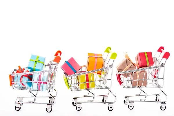 Decorative small shopping carts with gift boxes isolated on white — Stock Photo