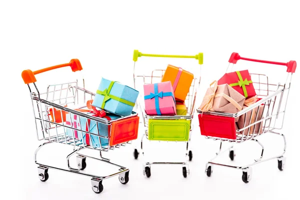 Decorative small shopping carts with gift boxes isolated on white — Stock Photo