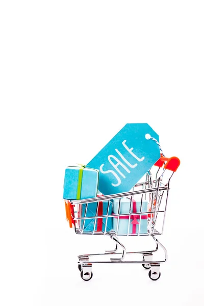 Petit panier décoratif avec boîtes-cadeaux et étiquette de prix avec vente lettrage isolé sur blanc — Photo de stock
