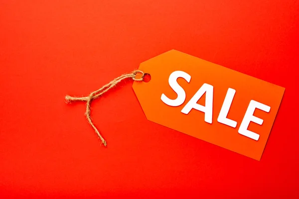 Vista superior da etiqueta de preço com venda lettering isolado no vermelho — Fotografia de Stock