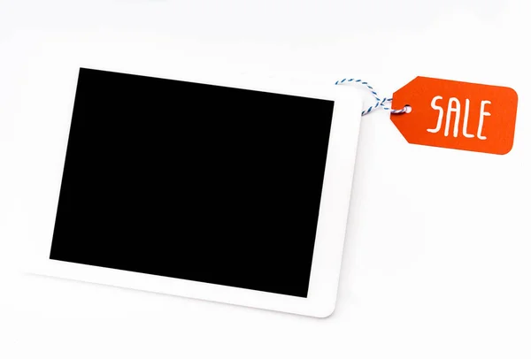 Vista superior de la tableta digital con pantalla en blanco con etiqueta de precio rojo con letras de venta aisladas en blanco - foto de stock