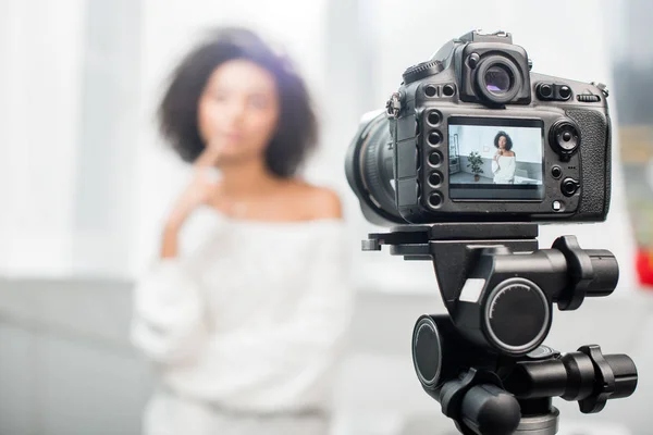 Foyer sélectif de l'appareil photo numérique avec influenceur afro-américain coûteux toucher le visage sur l'écran — Photo de stock