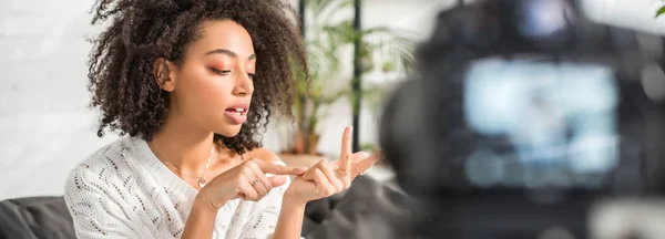 Panoramaaufnahme eines afrikanisch-amerikanischen inftuencer, der finger in der nähe der digitalkamera zählt — Stockfoto