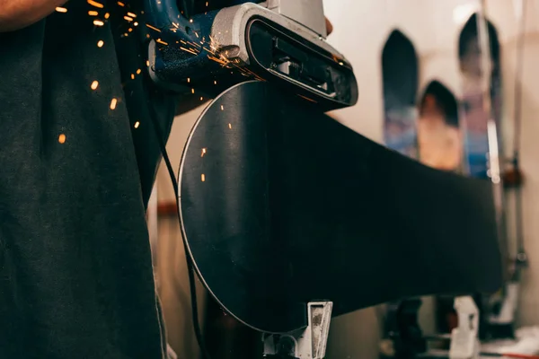 Cropped view of worker repairing snowboard with belt sander in repair shop — Stock Photo