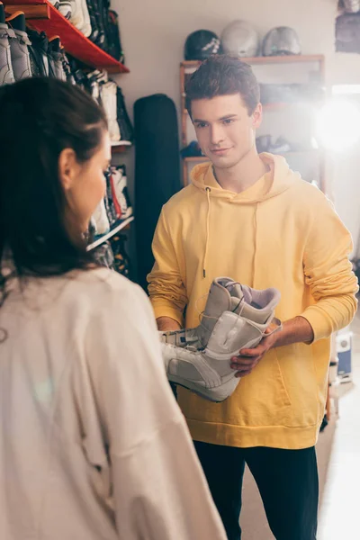 Foyer sélectif du travailleur montrant chaussures de ski au client dans l'atelier de réparation — Photo de stock