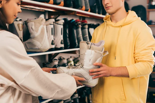 Cropped view of worker showing ski boot to client in repair shop — Stock Photo