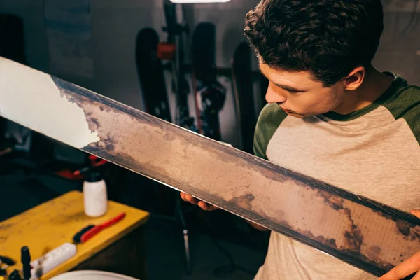 Vue aérienne du travailleur tenant des skis dans un atelier de réparation — Photo de stock