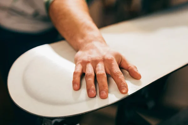 Vue recadrée du travailleur touchant snowboard dans l'atelier de réparation — Photo de stock