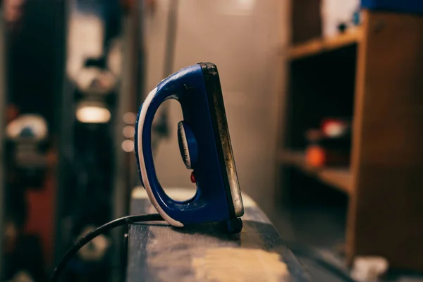 Mise au point sélective du fer à cire sur le ski dans l'atelier de réparation — Photo de stock