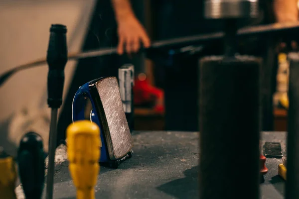 Foyer sélectif de fer de cire et le travailleur sur le fond dans l'atelier de réparation — Photo de stock