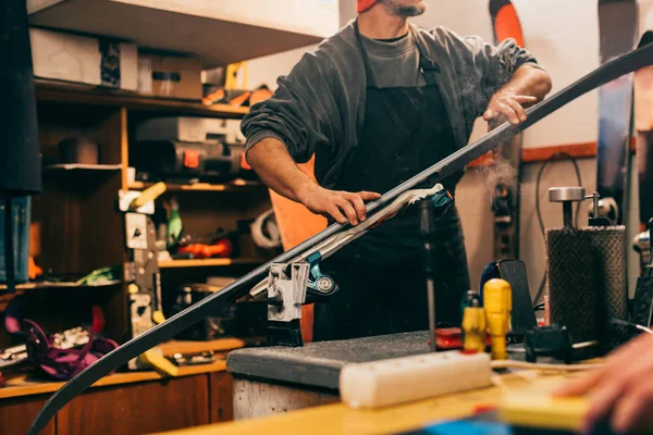 Vue recadrée du travailleur réparant le snowboard dans l'atelier de réparation — Photo de stock