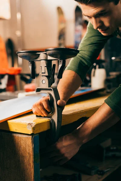 Cropped view of worker holding grip vice in repair shop — Stock Photo