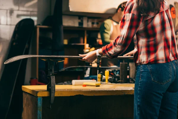 Ausgeschnittene Ansicht eines Arbeiters, der Ski in der Werkstatt hält — Stockfoto