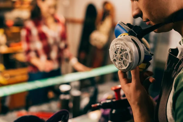 Cropped view of worker holding respirator in repair shop — Stock Photo