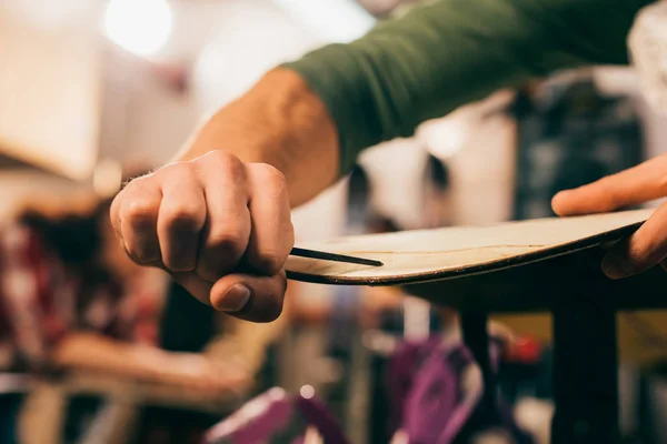 Cropped view of worker repairing snowboard in repair shop — Stock Photo