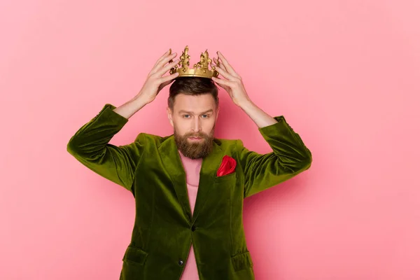 Man in velour jacket wearing crown on pink background — Stock Photo