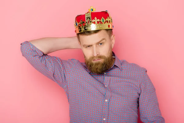 Serious man with crown looking at camera on pink background — Stock Photo