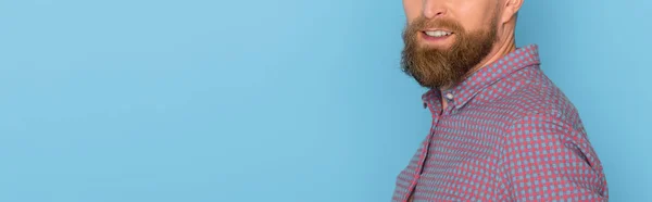 Панорамний знімок усміхненого чоловіка ізольовано на синьому з копіювальним простором — стокове фото