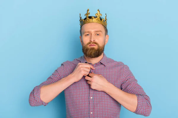 Serious man with crown looking at camera on blue background — Stock Photo