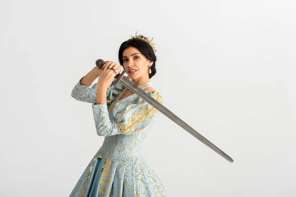 Reina sonriente con corona sosteniendo espada aislada en gris - foto de stock