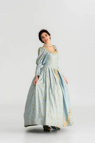 Atractiva reina en vestido con corona mirando a la cámara sobre fondo gris — Stock Photo