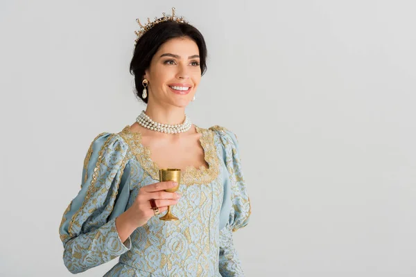 Reine souriante avec couronne tenant tasse isolé sur gris — Photo de stock