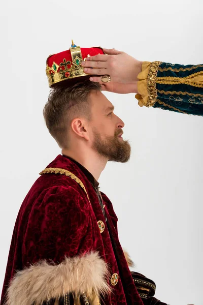 Corte vista do homem colocando coroa sobre o rei no fundo cinza — Fotografia de Stock