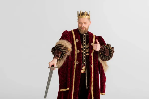 Smiling king with crown holding sword and showing like isolated on grey — Stock Photo