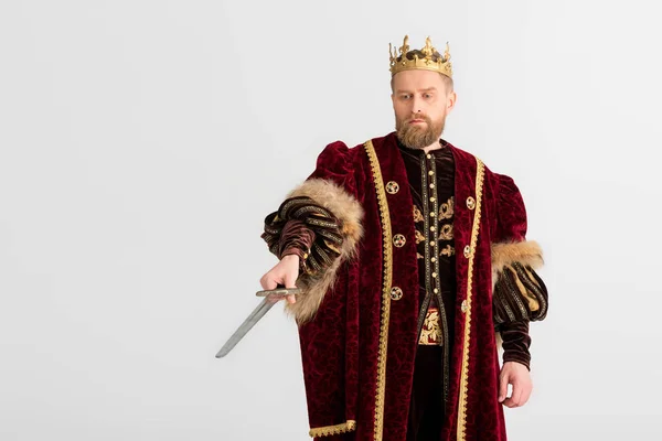 Король з короною, що вказує на меч ізольовано на сірому — стокове фото
