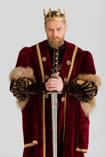 Serious king with crown holding sword isolated on grey — Stock Photo