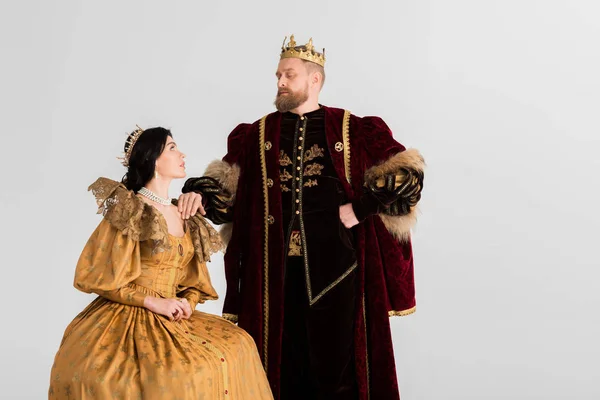 Rainha e rei com coroas olhando uns para os outros isolados em cinza — Fotografia de Stock