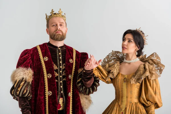 Queen and king with crowns holding hands isolated on grey — Stock Photo