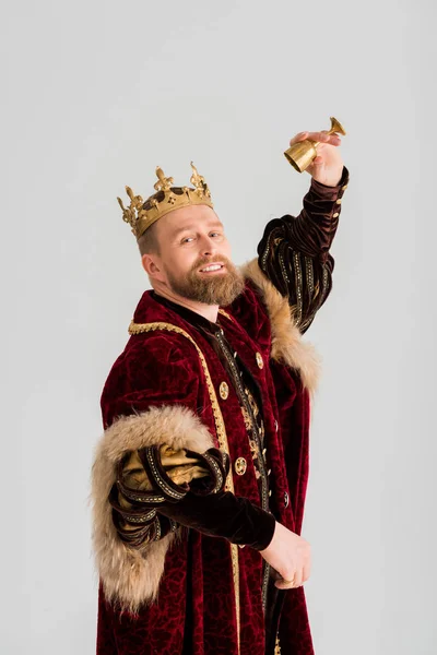 Усміхнений король з короною тримає чашку ізольовано на сірому — стокове фото