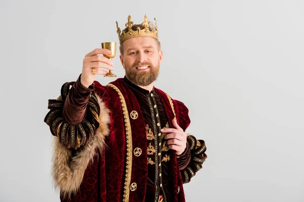Rei sorrindo com coroa segurando copo isolado em cinza — Fotografia de Stock