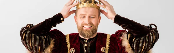 Panoramic shot of smiling king wearing crown on head isolated on grey — Stock Photo