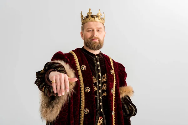 Handsome king with crown showing hand isolated on grey — Stock Photo
