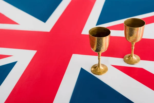 Tasses dorées et anciennes sur drapeau britannique avec espace de copie — Photo de stock