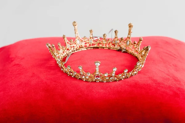 Coroa real no travesseiro vermelho isolado no branco — Fotografia de Stock