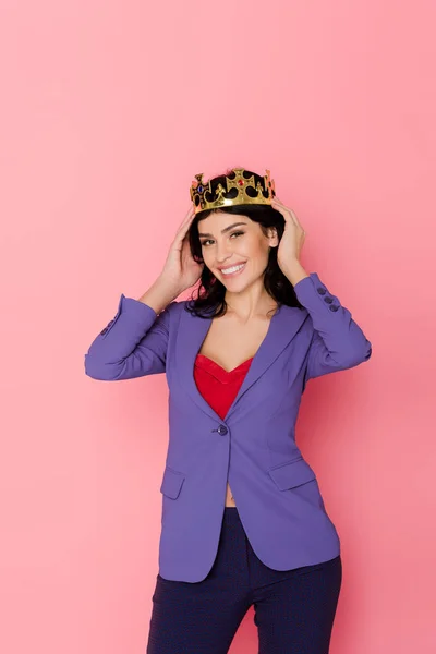 Smiling woman with crown looking at camera on pink background — Stock Photo