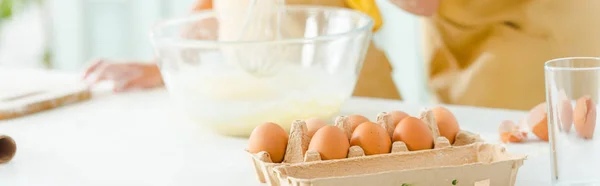 Panoramic shot of eggs near african american kid and mother — Stock Photo